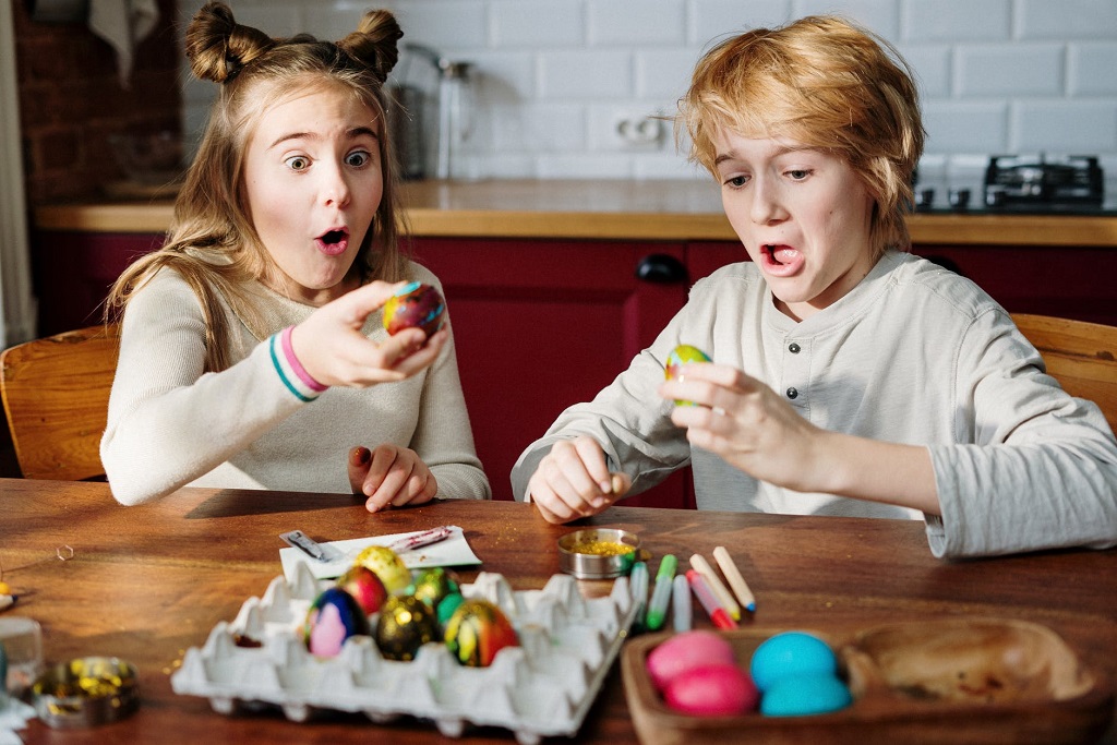 Dos niños decorando los huevos de pascua